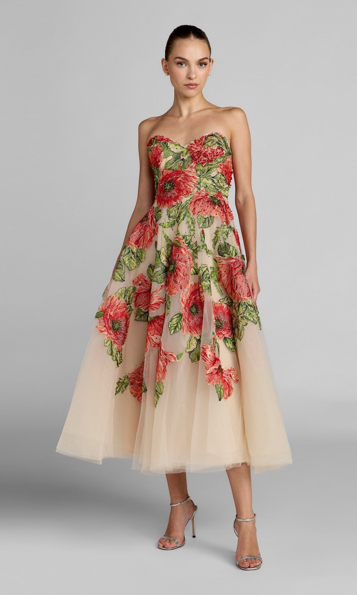 A woman wearing the Mac Duggal 21300 Tea-Length Party Dress in Nude Multi stands against a plain gray background.